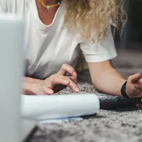 A person reviewing paperwork with a calculator at home