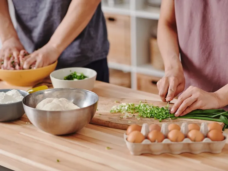 Two people preparing a meal together in a bright kitchen